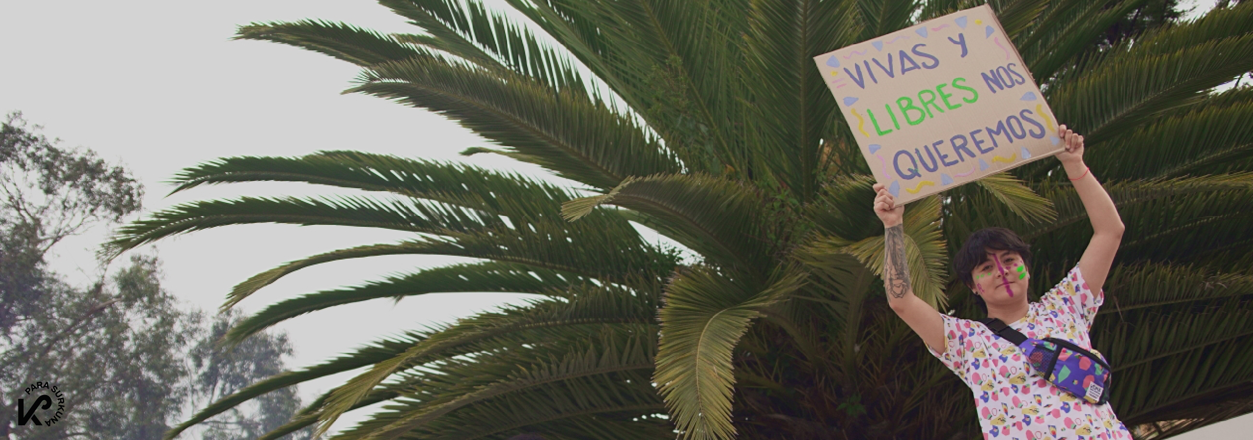 Persona no-binaria modela camiseta blanca con diseño geométrico de Kuna.